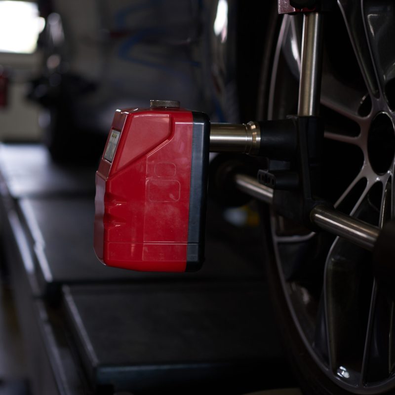 Closeup photoshoot of process or tyre balancing at dark auto service.